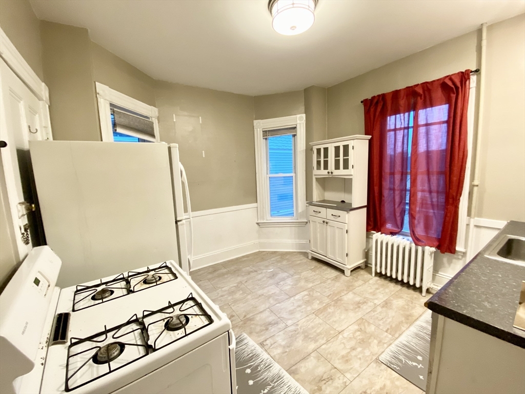 12 Highland Avenue, Unit 2 Beverly, MA 01915 - Photo 4 of 7 a view of a kitchen with wooden floor and electronic appliances