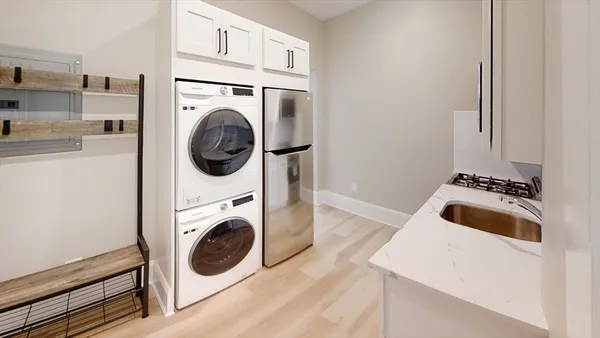 a utility room with dryer washer and a view of kitchen