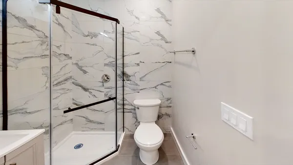 a bathroom with a toilet and a shower