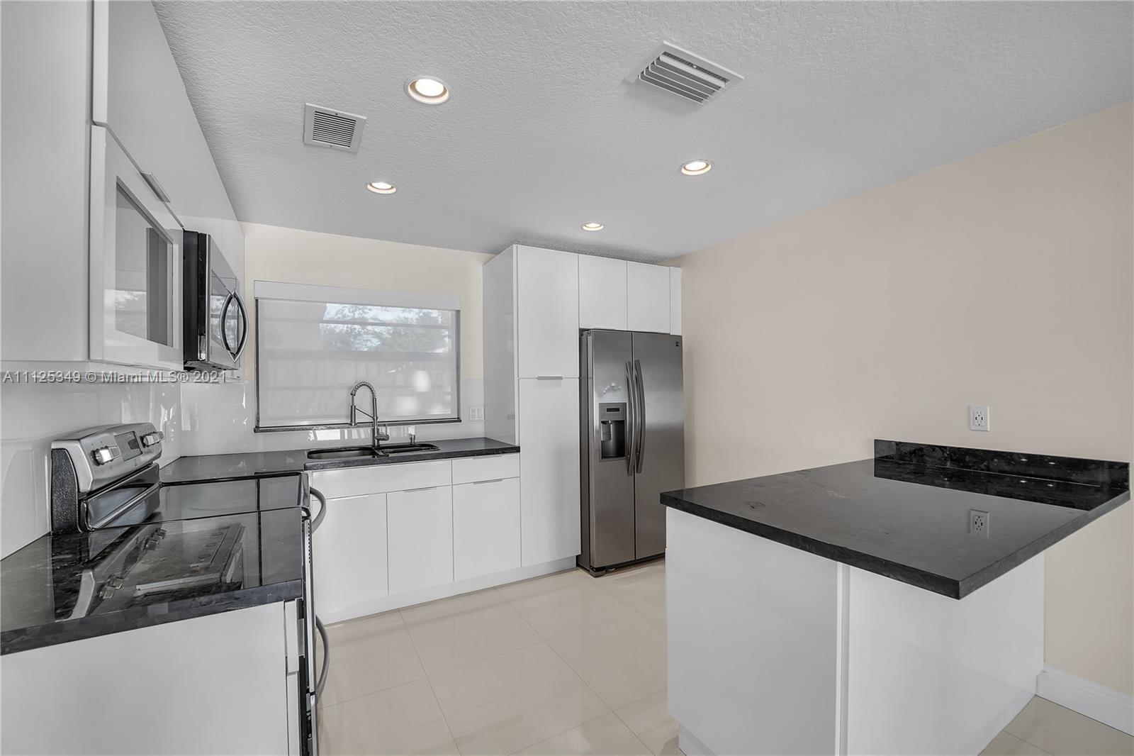 The Crossings Miami, FL 33186 - Photo 12 of 31 a kitchen with stainless steel appliances granite countertop a sink stove and refrigerator