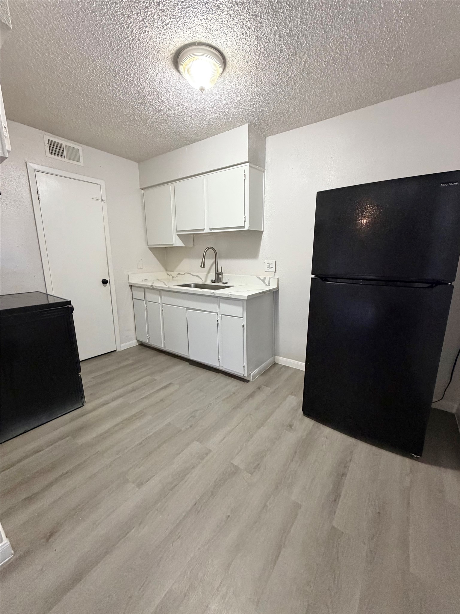 1614 Vauthier Street, Unit 3 La Marque, TX 77568 - Photo 5 of 13 a kitchen with a sink and a refrigerator