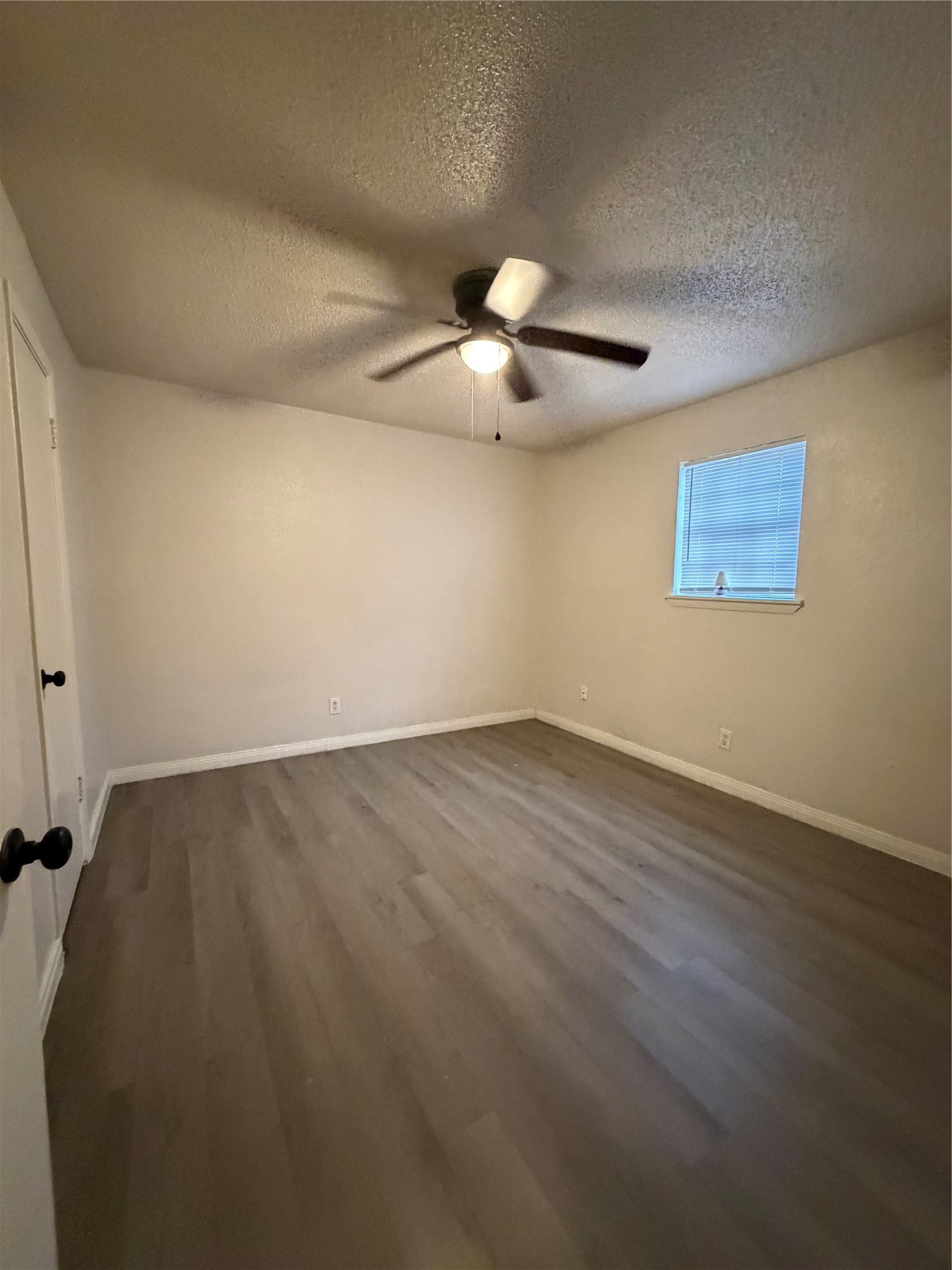 1614 Vauthier Street, Unit 3 La Marque, TX 77568 - Photo 10 of 13 an empty room with wooden floor chandelier fan and windows