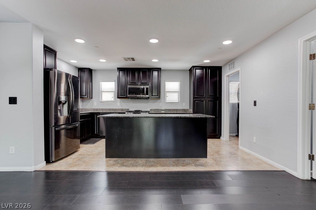 7724 Vibrant Thread Court Las Vegas, NV 89149 - Photo 6 of 43 Culinary creativity awaits in this kitchen featuring dark cabinetry and a spacious central island.