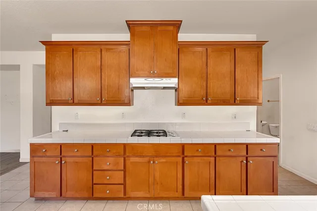 a kitchen with stainless steel appliances granite countertop wooden cabinets and window