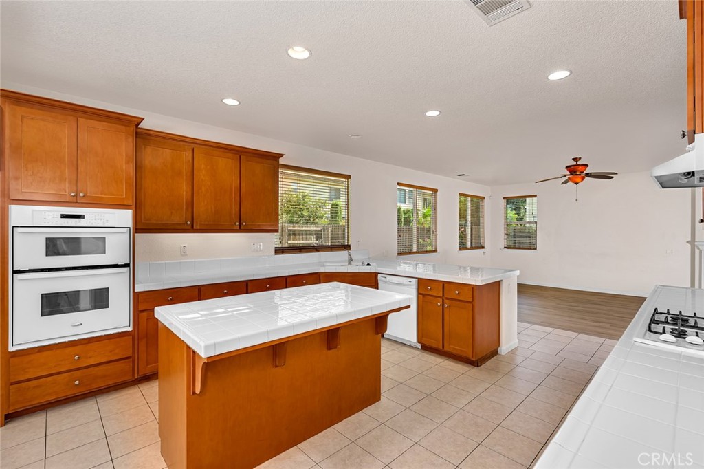1289 Verdon Court Merced, CA 95348 - Photo 19 of 56 a kitchen with stainless steel appliances granite countertop wooden cabinets and window