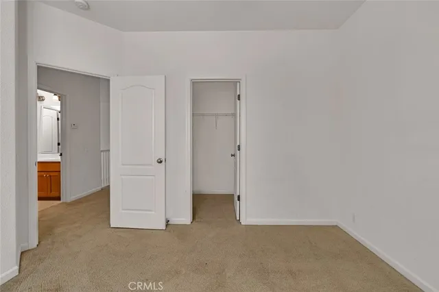 an empty room with windows and ceiling fan