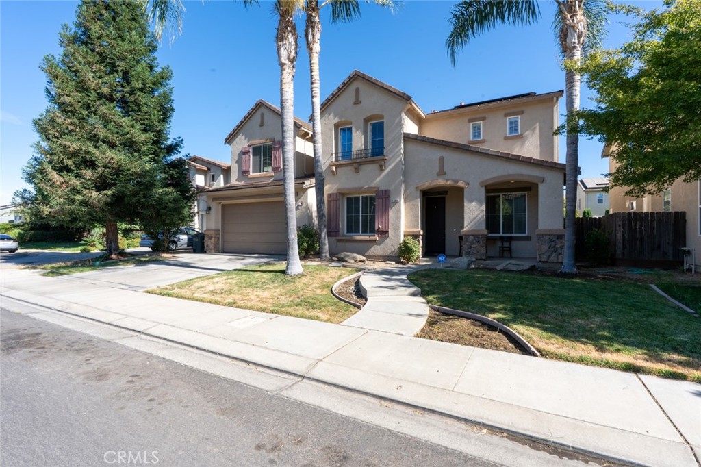 1289 Verdon Court Merced, CA 95348 - Photo 4 of 56 a view of a white house with a yard plants and a large tree