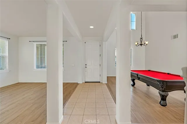 a view of an empty room with wooden floor and windows