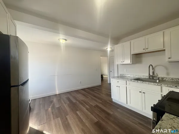 a kitchen with granite countertop a sink cabinets and stainless steel appliances