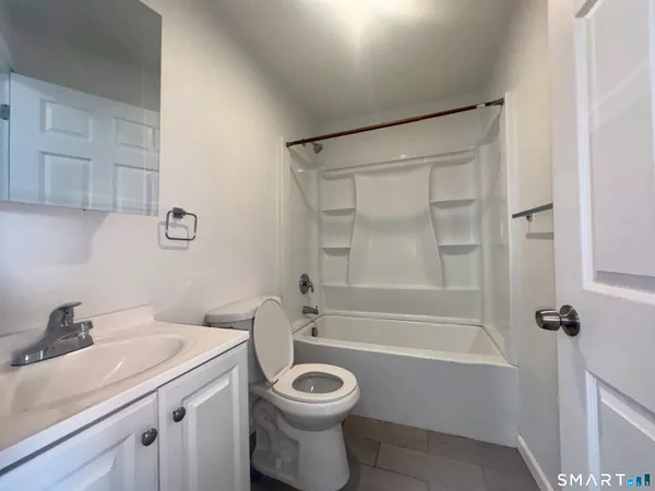 a bathroom with a granite countertop toilet a sink and bathtub