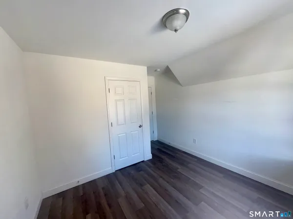 a view of a room with wooden floor and white walls
