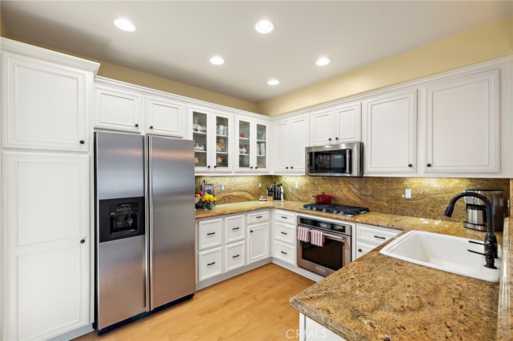 8 Earthen Court Ladera Ranch, CA 92694 - Photo 15 of 58 a kitchen with stainless steel appliances granite countertop a refrigerator a stove a sink and a microwave