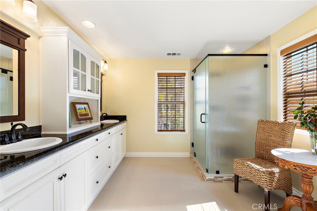 8 Earthen Court Ladera Ranch, CA 92694 - Photo 19 of 58 a bathroom with a double vanity sink a mirror a bathtub and next to a window