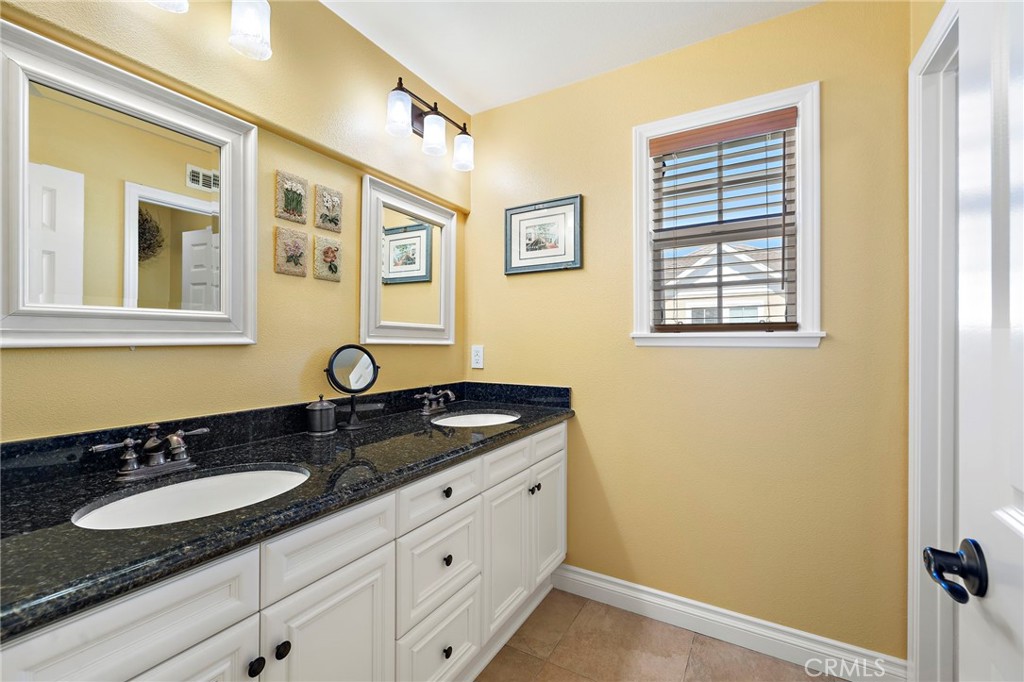 8 Earthen Court Ladera Ranch, CA 92694 - Photo 25 of 58 a bathroom with a granite countertop double vanity sink and mirror
