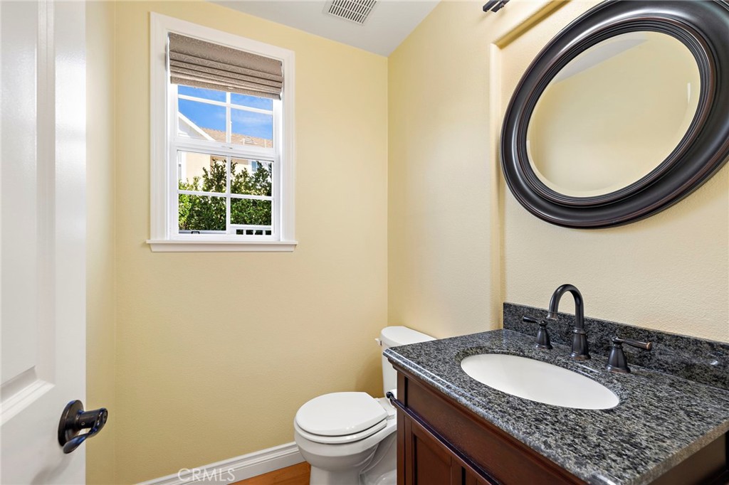 8 Earthen Court Ladera Ranch, CA 92694 - Photo 28 of 58 a bathroom with a granite countertop toilet a sink and a mirror