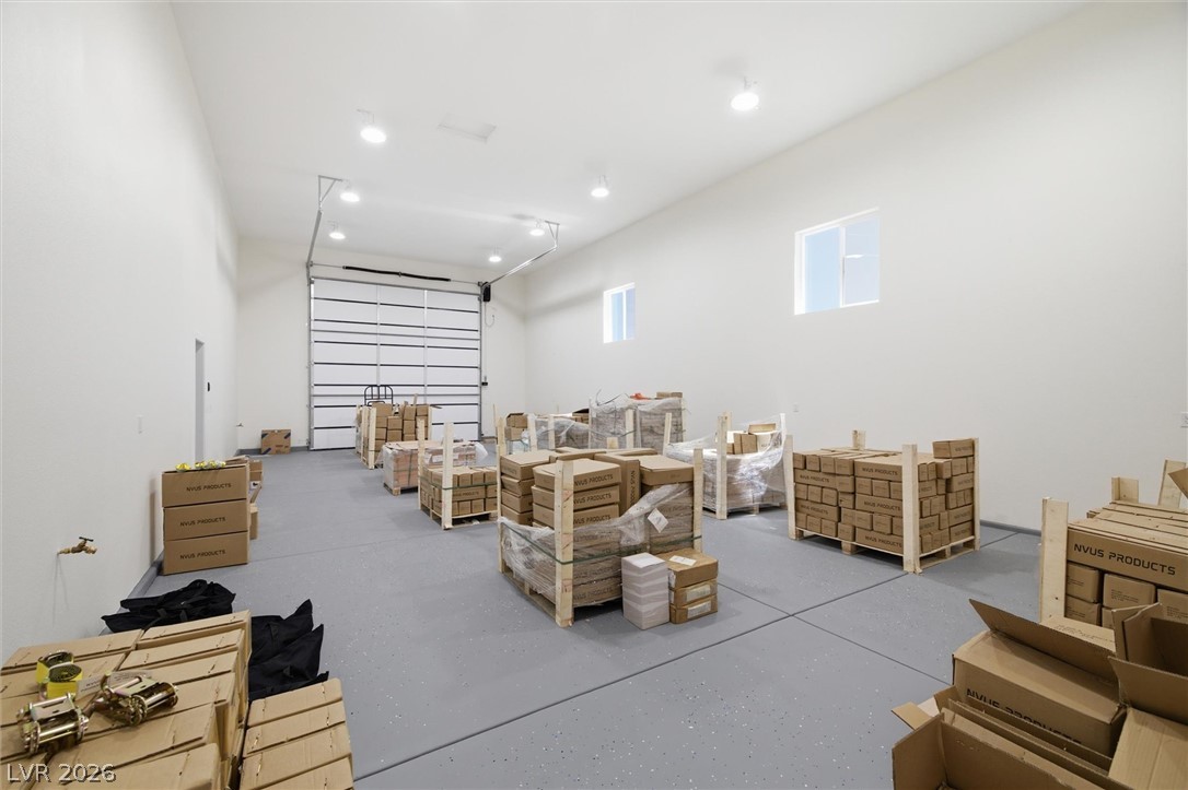 5910 East Kellogg Road Pahrump, NV 89061 - Photo 39 of 58 Vast interior space with high ceilings and a substantial garage door offers versatile utility.