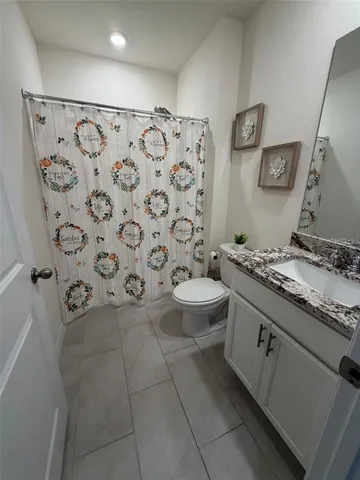 a bathroom with a granite countertop toilet sink and mirror