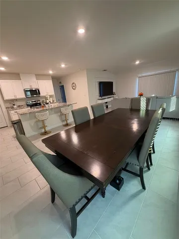 a large kitchen with stainless steel appliances a table and chairs in it