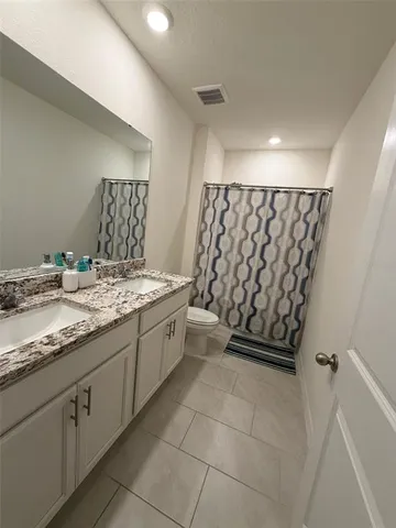 a bathroom with a granite countertop sink a vanity and a shower