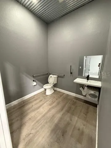 a bathroom with a sink a toilet and a mirror