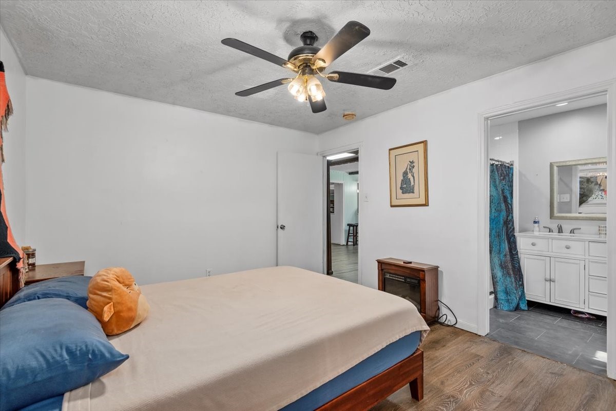 504 Catfish Lane Conroe, TX 77384 - Photo 18 of 48 a bedroom with a large bed and a chandelier
