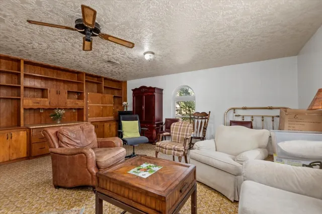 a living room with furniture a rug and white walls