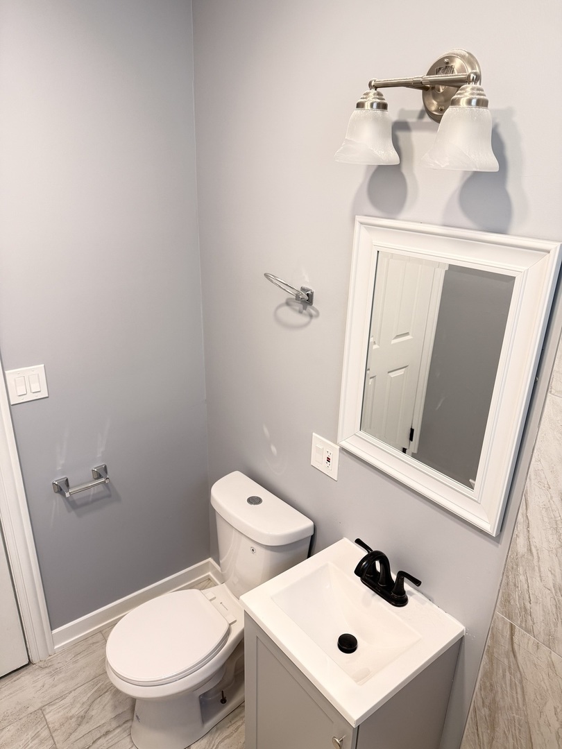 3821 West Fillmore Street, Unit 2R Chicago, IL 60624 - Photo 11 of 12 a white toilet sitting next to a bathroom sink