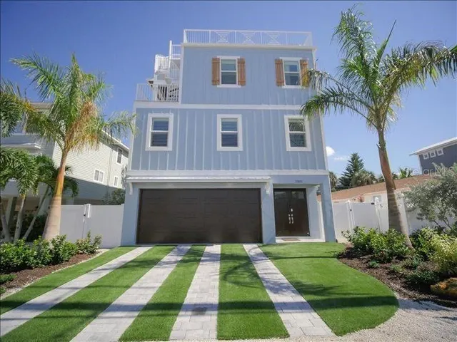 a front view of a house with yard and green space