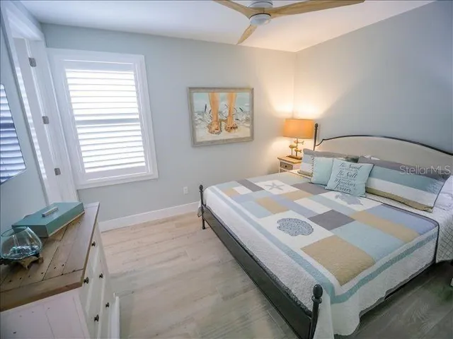 a bedroom with a bed and a lamp with the wooden floor