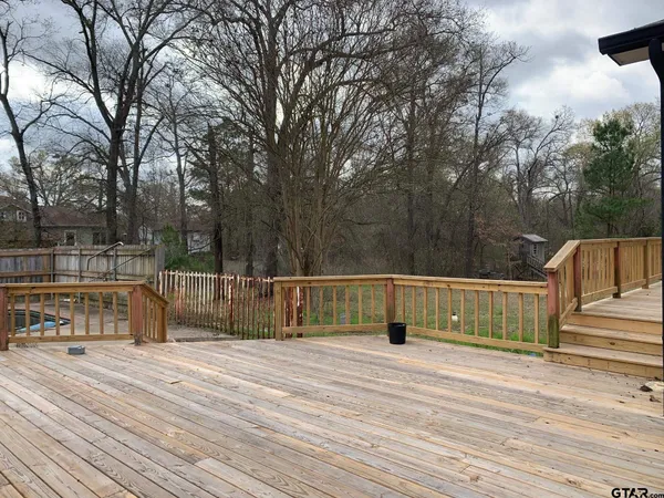 a view of deck with trees and barbeque oven