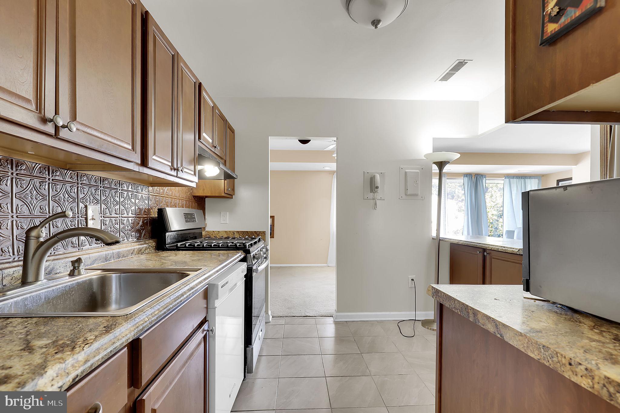 19309 Club House Road, Unit 19309 Gaithersburg, MD 20886 - Photo 2 of 24 a kitchen with a sink a refrigerator and cabinets