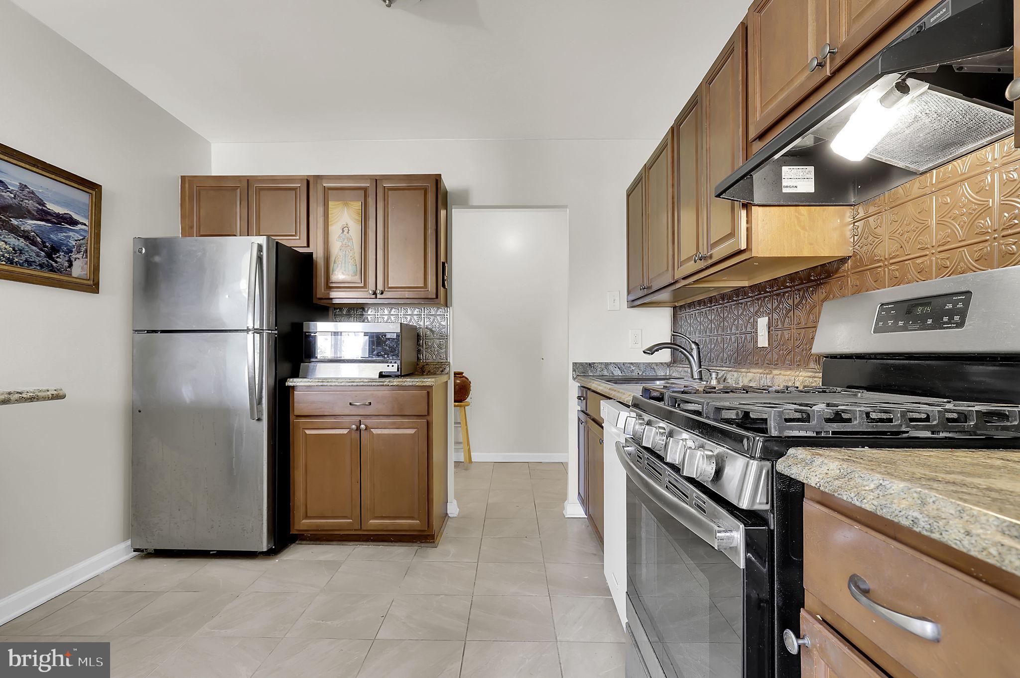 19309 Club House Road, Unit 19309 Gaithersburg, MD 20886 - Photo 3 of 24 a kitchen with stainless steel appliances granite countertop a stove a refrigerator and a refrigerator