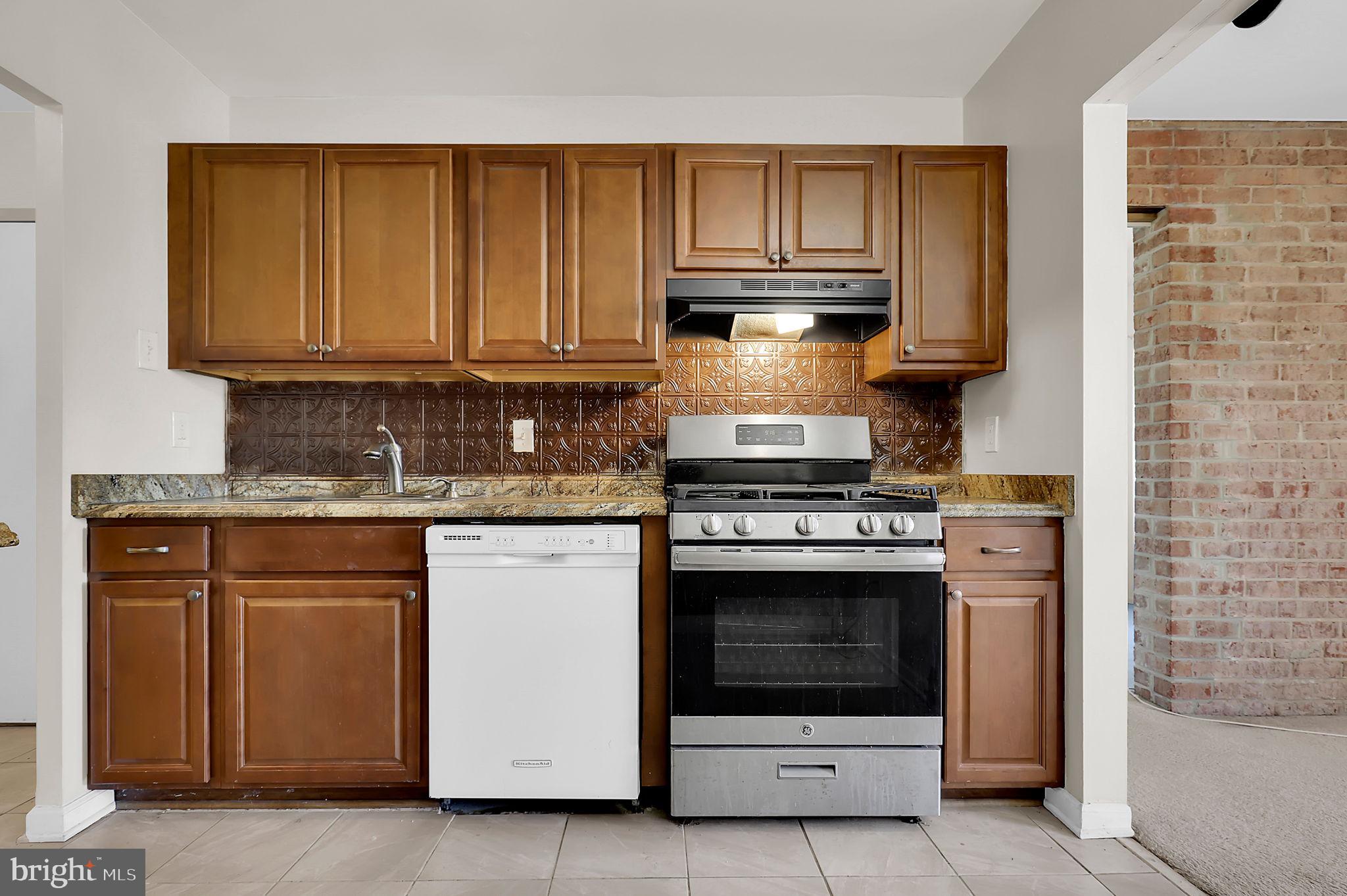 19309 Club House Road, Unit 19309 Gaithersburg, MD 20886 - Photo 5 of 24 a kitchen with stainless steel appliances granite countertop a stove and a microwave