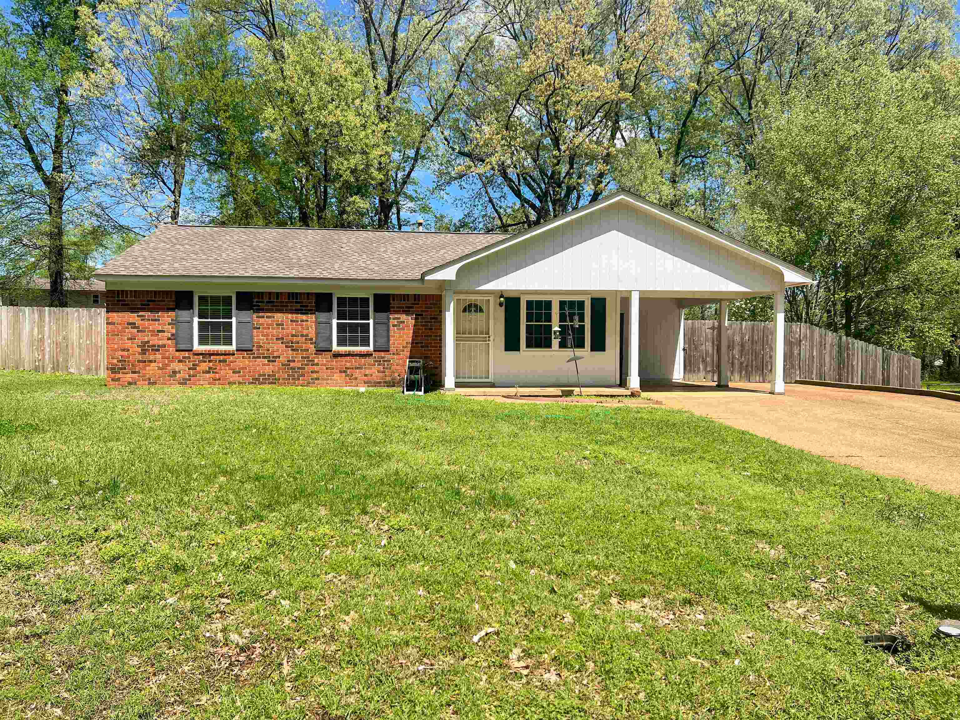 520 Jeffrey Lane Collierville, TN 38017 - Photo 1 of 11 Ranch-style house featuring fence, a front lawn, brick siding, concrete driveway, and an attached carport