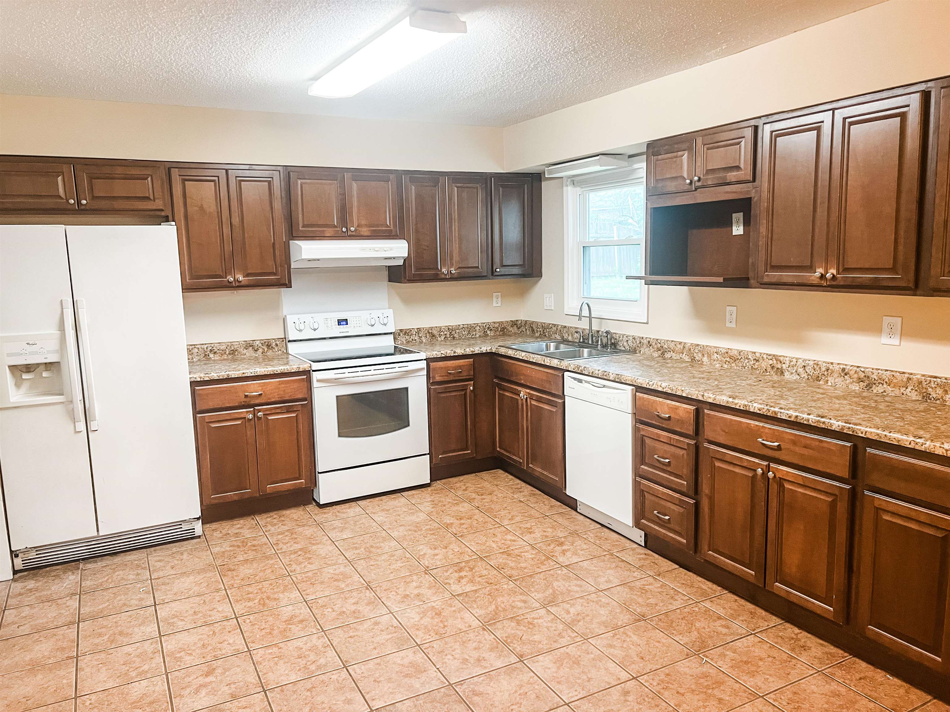 520 Jeffrey Lane Collierville, TN 38017 - Photo 3 of 11 Kitchen with a textured ceiling, under cabinet range hood, a sink, and white appliances