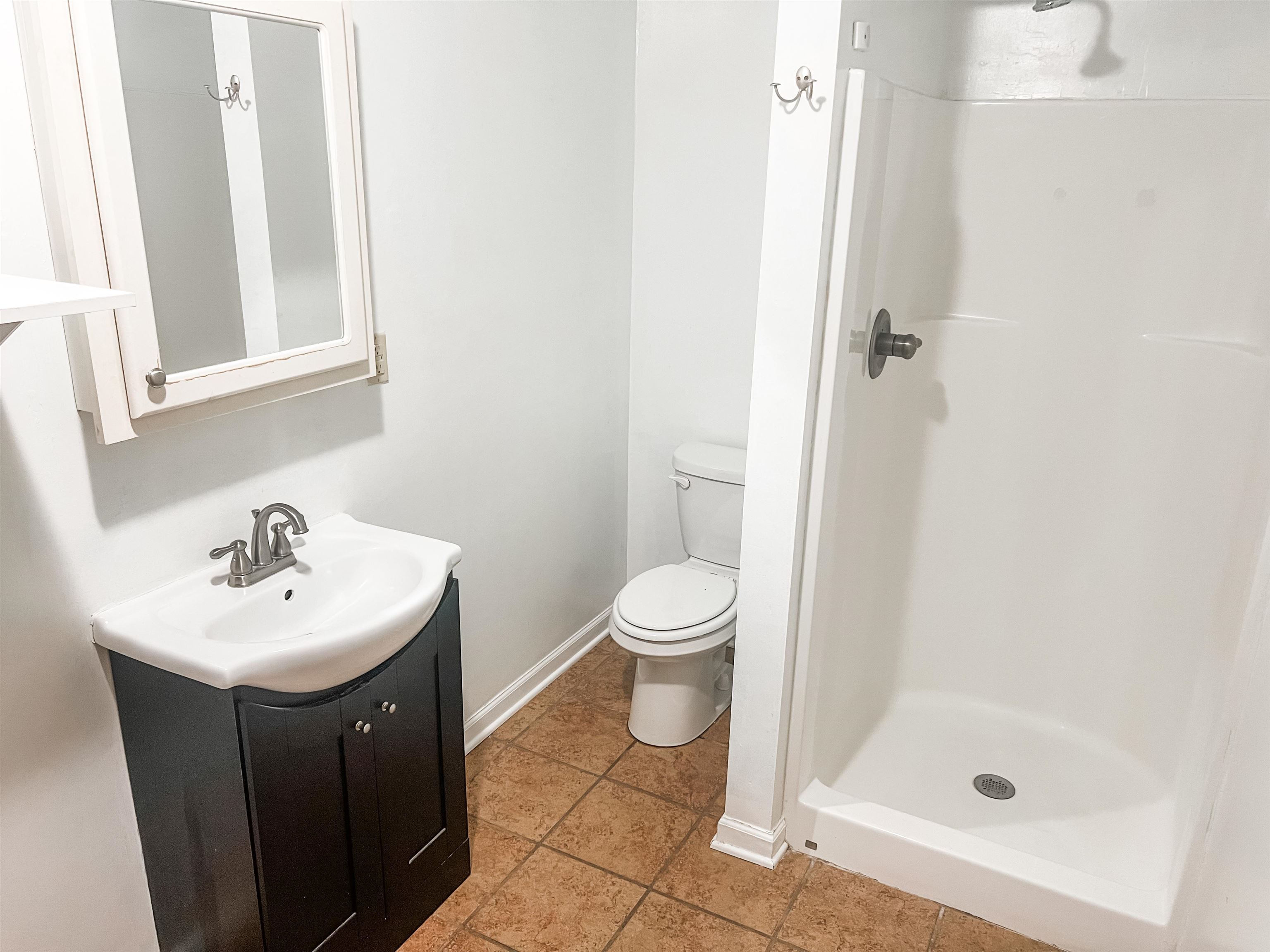 520 Jeffrey Lane Collierville, TN 38017 - Photo 5 of 11 Bathroom featuring toilet, vanity, baseboards, and a stall shower