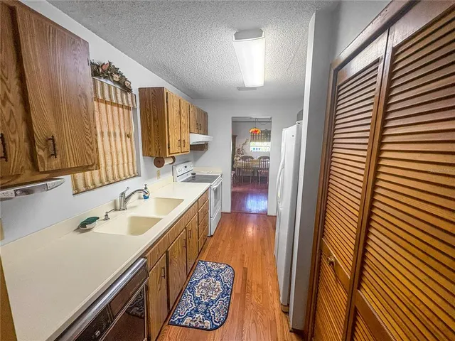 an empty room with a chandelier fan and windows