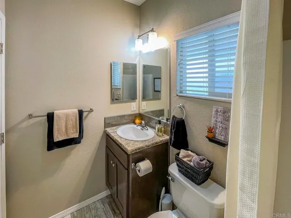 a bathroom with a sink a toilet and mirror