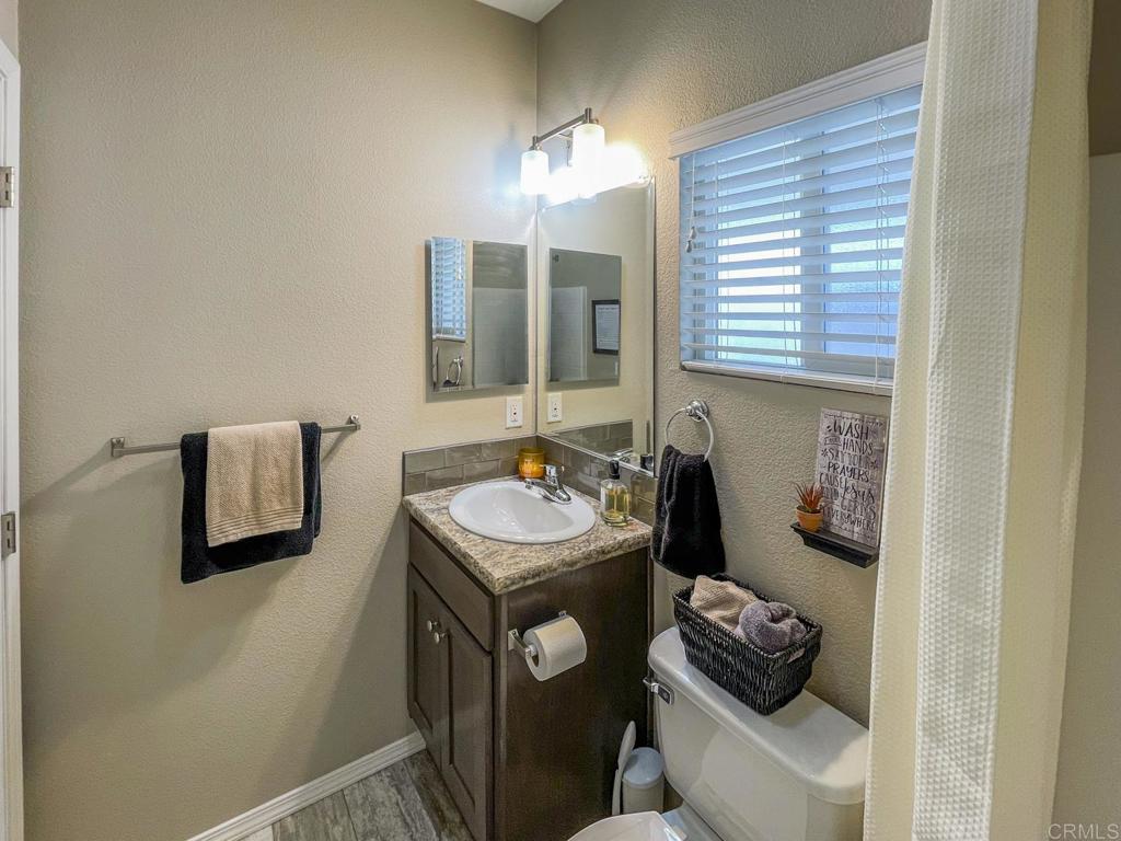 8545 Mission Gorge Road, Unit SPC 211 Santee, CA 92071 - Photo 15 of 33 a bathroom with a sink a toilet and mirror
