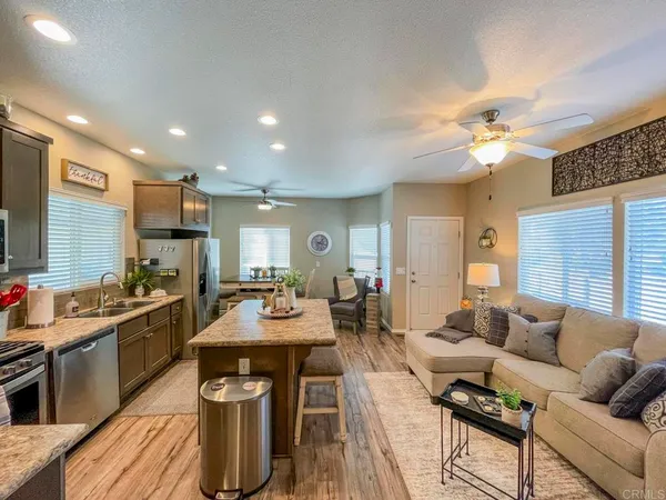 a living room with furniture a dining table and kitchen view