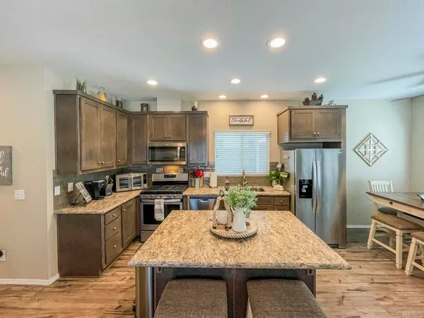 a kitchen with a table chairs and refrigerator
