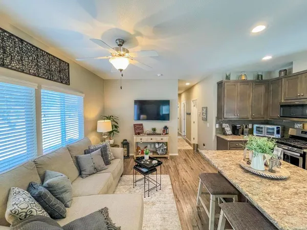 a living room with furniture a flat screen tv and kitchen view