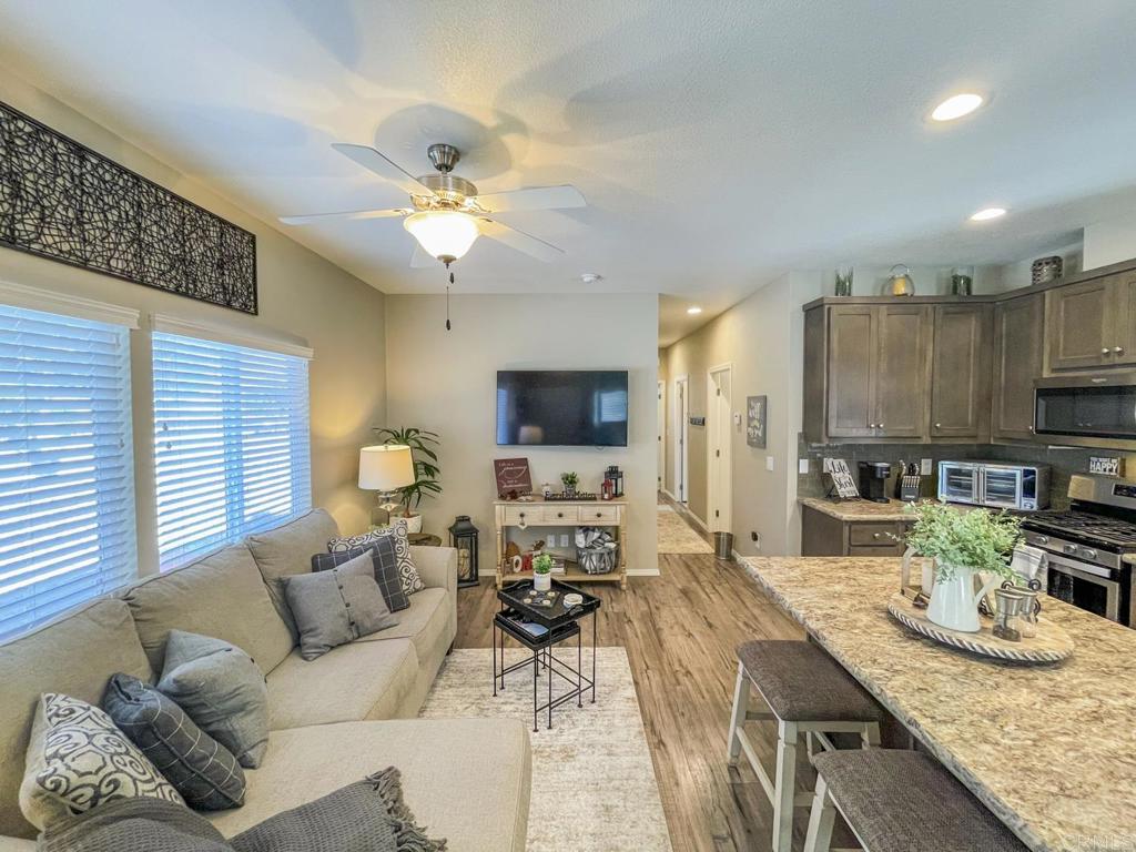 8545 Mission Gorge Road, Unit SPC 211 Santee, CA 92071 - Photo 21 of 33 a living room with furniture a flat screen tv and kitchen view