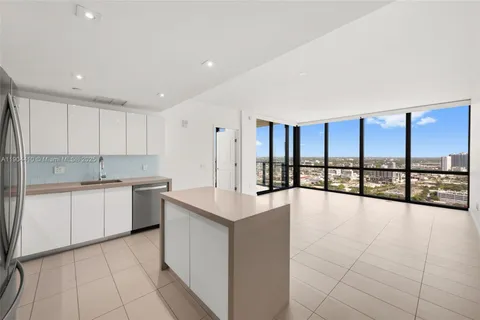 a large white kitchen with a large window