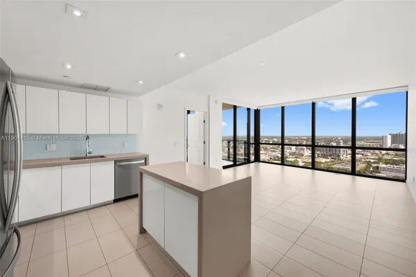 a large white kitchen with a large window
