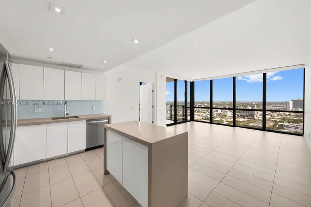 a large white kitchen with a large window