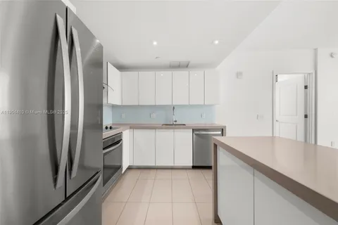 a kitchen with a refrigerator sink and cabinets