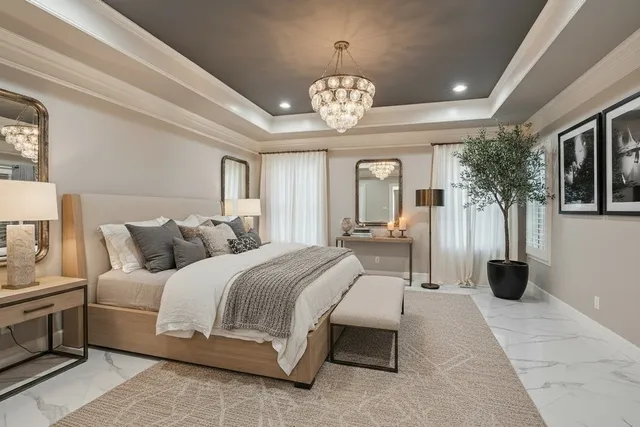 a spacious bedroom with a bed and a chandelier