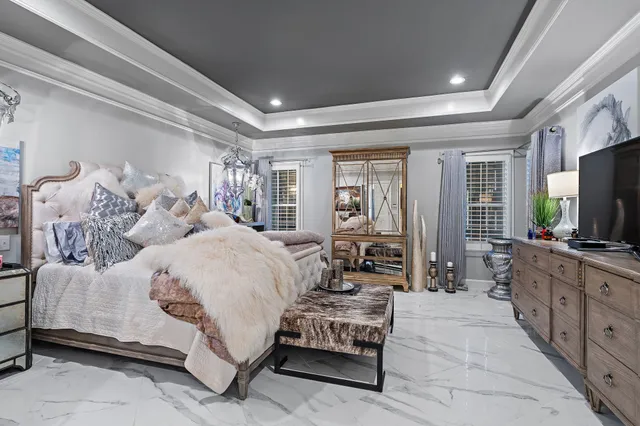 a spacious bedroom with a bed and a flat screen tv