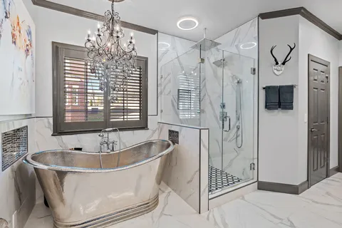 a spacious bathroom with a tub sink shower and mirror